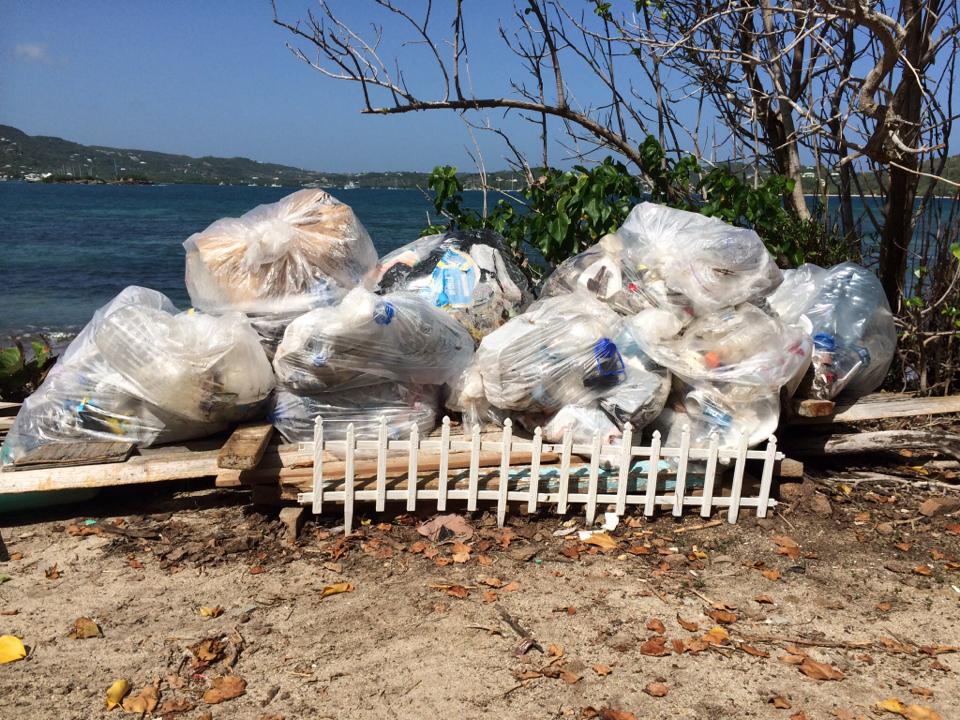 pile of trash bags on a beach