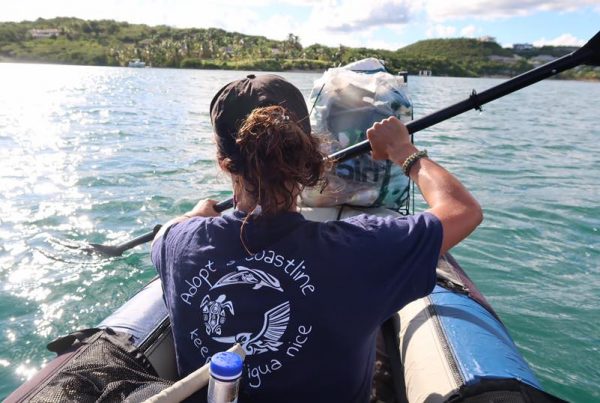 woman kayaking picking up rubbish