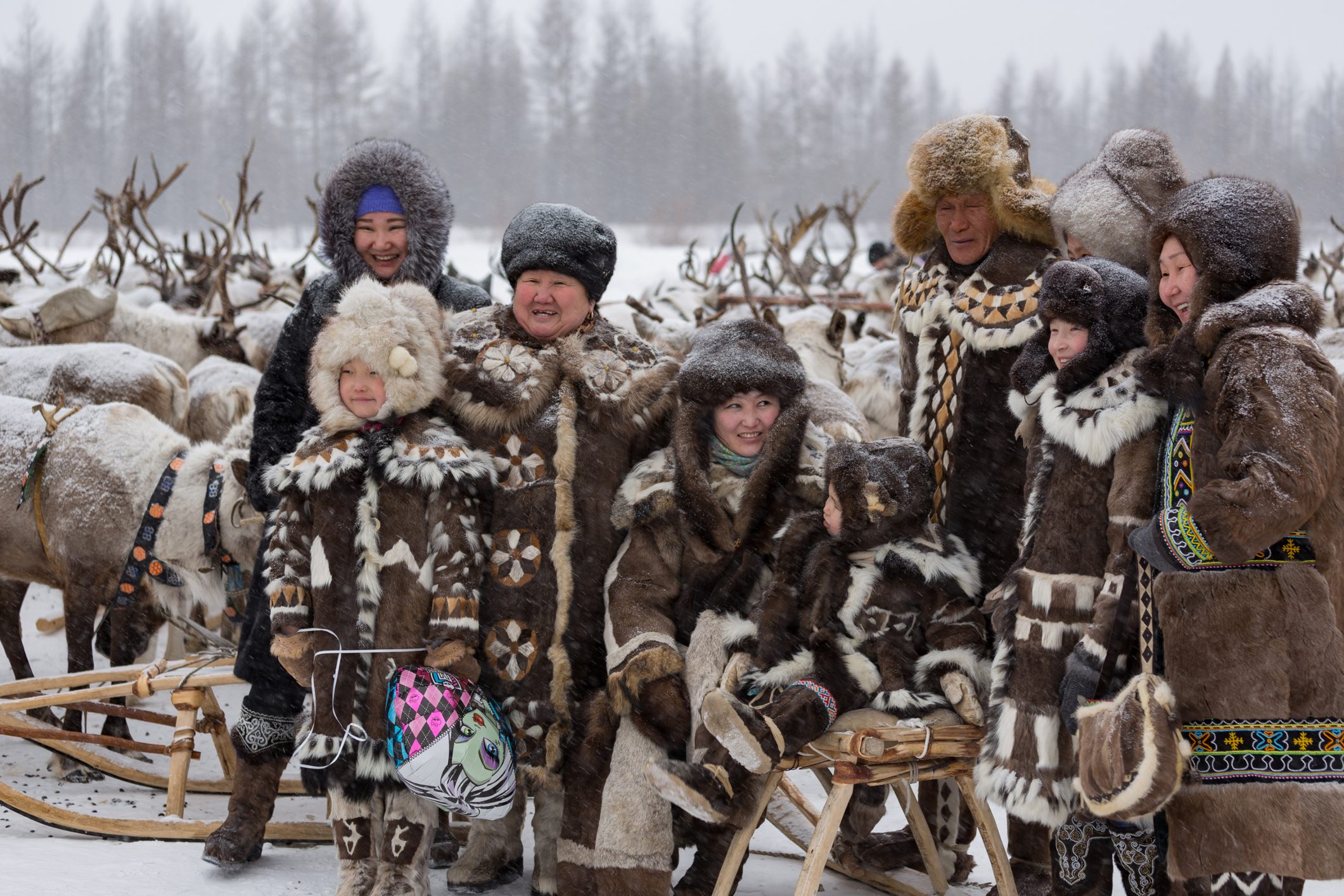 Una familia evenk con trajes típicos en la celebración del reno en Yakutia
